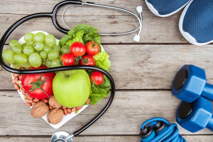 Stethoscope Wrapped Around a Heart-Shaped Plate of Fruits and Veggies Next to Exercise Equipment | Salt for Health Conscious People | Boulder Salt Company