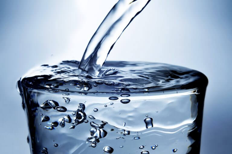 Water Pouring Into a Glass with one quarter teaspoon of Boulder Salt with Electrolytes