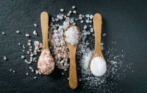 quarter teaspoons of different salts, one is healthy salt with electrolytes