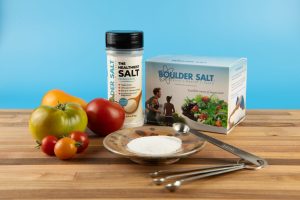bottle of boulder salt with a box of packets with healthy food